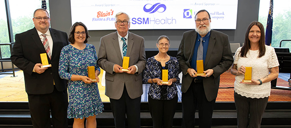 2025 Golden Brick Award winners standing in front of a stage